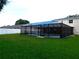 Wide view of the backyard pool area covered with black screening and decorative lighting strung throughout at 15916 Marshfield Dr, Tampa, FL 33624
