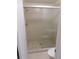 Tiled shower with glass door, neutral tile, shower head, and grab bar for safety at 15916 Marshfield Dr, Tampa, FL 33624