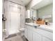 Modern bathroom with dual sinks, a walk-in shower with patterned curtains, and neutral decor at 16624 Maude Dr, Wimauma, FL 33598
