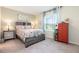 Serene bedroom featuring a floral patterned bedspread, side tables, and a bright window at 16624 Maude Dr, Wimauma, FL 33598
