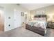 Comfortable bedroom with floral bedding, carpet floors, and ensuite bathroom and closet access at 16624 Maude Dr, Wimauma, FL 33598