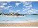 View of community pool featuring beach entry, splashpad, waterslides and lounge chairs on a clear day at 16624 Maude Dr, Wimauma, FL 33598