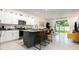 Stylish kitchen island with seating, granite countertops, and stainless steel appliances at 16624 Maude Dr, Wimauma, FL 33598