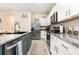 Modern kitchen with granite countertops, stainless steel appliances, and ample cabinet space at 16624 Maude Dr, Wimauma, FL 33598