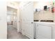 Functional laundry room with a modern washer and dryer, shelving, and access to additional storage at 16624 Maude Dr, Wimauma, FL 33598