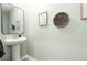Well-decorated half bathroom featuring a pedestal sink, and stylish wall decor at 16624 Maude Dr, Wimauma, FL 33598