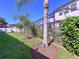 Landscaped backyard featuring a screened-in patio, lush green grass, decorative trees, and a well-maintained garden at 1947 Marshberry Ct, Trinity, FL 34655