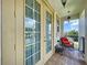 Doors opening onto the tiled balcony with outdoor furniture and a peaceful view at 1947 Marshberry Ct, Trinity, FL 34655