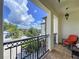 Balcony features a black metal railing, tile floor, and comfortable rocking chair to sit and relax at 1947 Marshberry Ct, Trinity, FL 34655