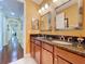 Bathroom features double sinks, granite countertops and a view into the hallway at 1947 Marshberry Ct, Trinity, FL 34655
