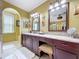Elegant primary bathroom vanity with granite countertop, dual mirrors, and modern fixtures, offering style and functionality at 1947 Marshberry Ct, Trinity, FL 34655