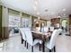Bright dining room with view to outdoor patio, features modern light fixture and seating for six at 1947 Marshberry Ct, Trinity, FL 34655