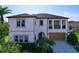 Stately two-story home boasting a covered balcony, arched doorway, manicured landscaping, and a two-car garage at 1947 Marshberry Ct, Trinity, FL 34655