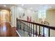 Upstairs hallway featuring wood floors, elegant art, chandelier, and an open view of the entry area at 1947 Marshberry Ct, Trinity, FL 34655