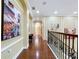 Hallway featuring hardwood floors, arched doorways, decorative wall paintings, and bench seating at 1947 Marshberry Ct, Trinity, FL 34655
