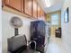 Well-organized laundry room featuring cabinets, modern black washer and dryer, tile flooring, and a hair-wash chair at 1947 Marshberry Ct, Trinity, FL 34655
