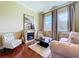 Elegant living room featuring a fireplace, hardwood floors, large windows, and neutral color palette at 1947 Marshberry Ct, Trinity, FL 34655