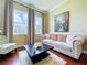 Cozy living room with hardwood floors, a comfortable sofa, designer accents, and large windows at 1947 Marshberry Ct, Trinity, FL 34655