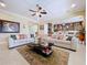 Bright living room with a coffered ceiling, fan, and comfortable seating, flowing seamlessly into the kitchen at 1947 Marshberry Ct, Trinity, FL 34655