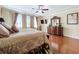Spacious primary bedroom with large dresser, hardwood floors, and ceiling fan, offering style and comfort at 1947 Marshberry Ct, Trinity, FL 34655