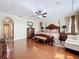 Luxurious primary bedroom boasts hardwood floors, decorative touches, and plenty of natural light at 1947 Marshberry Ct, Trinity, FL 34655