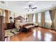 Stunning primary bedroom featuring hardwood floors, luxury bedding, tray ceilings, and natural light at 1947 Marshberry Ct, Trinity, FL 34655