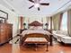 Elegant primary bedroom featuring coffered ceilings, a ceiling fan, and dark, shining hardwood floors at 1947 Marshberry Ct, Trinity, FL 34655