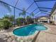 Screened-in pool with brick patio, and lush tropical landscaping offering a private backyard retreat at 1947 Marshberry Ct, Trinity, FL 34655