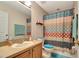 Cozy bathroom with colorful shower curtain, single vanity, and plush blue bathmat at 213 Draw Bridge Ln, Valrico, FL 33594