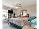 Bright bedroom features large window, ceiling fan, bureau, and colorful patterned bedding at 213 Draw Bridge Ln, Valrico, FL 33594