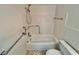 Bathroom featuring a white tub with shower fixtures, tiled walls, and safety bars for accessibility at 2391 Sumatran Way # 37, Clearwater, FL 33763