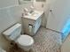 Cozy bathroom featuring a toilet, vanity with sink, and classic tiled walls and flooring at 2391 Sumatran Way # 37, Clearwater, FL 33763