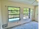 Bright Florida Room with two windows overlooking lush greenery, ready for customization and transformation at 2391 Sumatran Way # 37, Clearwater, FL 33763