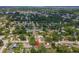 Expansive aerial view of a neighborhood showcasing various single-Gathering homes and lush green trees at 2824 Paddock Dr, Palm Harbor, FL 34684