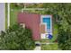 Aerial view of the property showcasing the backyard pool, patio, and surrounding lush greenery at 2824 Paddock Dr, Palm Harbor, FL 34684