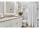 This bathroom features a vanity with granite counters, a shower/tub combo and wood-look tile flooring at 2824 Paddock Dr, Palm Harbor, FL 34684