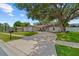 Charming home exterior with a circular driveway, mature landscaping, and stone accents at 2824 Paddock Dr, Palm Harbor, FL 34684