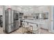 Modern kitchen with stainless steel appliances, quartz countertops, island seating and bright lighting at 2824 Paddock Dr, Palm Harbor, FL 34684