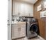 This laundry room features updated cabinets, modern washer and dryer and wood-look tile flooring at 2824 Paddock Dr, Palm Harbor, FL 34684