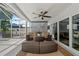 This screened-in patio features an outdoor ceiling fan, a comfortable seating area and sliding glass doors at 2824 Paddock Dr, Palm Harbor, FL 34684