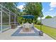 Outdoor patio showcases dining area, complemented by lush landscaping and blue accents at 2824 Paddock Dr, Palm Harbor, FL 34684