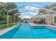 Stunning screened-in pool with a waterfall feature and ample seating areas perfect for outdoor enjoyment at 2824 Paddock Dr, Palm Harbor, FL 34684