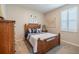 Bedroom featuring carpet flooring, a wooden bed frame, and a window with plantation shutters at 2898 Living Coral Dr, Odessa, FL 33556