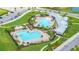 Aerial view of the community pool area featuring multiple pools, seating, and well-maintained landscaping at 2898 Living Coral Dr, Odessa, FL 33556