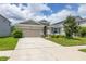 Charming single-story home featuring a well-maintained lawn, two-car garage, and lovely landscaping at 2898 Living Coral Dr, Odessa, FL 33556