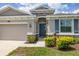 Close-up of the exterior with blue front door, stone accents, and a well-manicured lawn at 2898 Living Coral Dr, Odessa, FL 33556