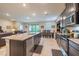 Open floor plan kitchen with island seating, stainless steel appliances, and direct sight lines to the living area at 2898 Living Coral Dr, Odessa, FL 33556