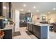 Open kitchen and living area with a large center island featuring granite countertops and stainless steel appliances at 2898 Living Coral Dr, Odessa, FL 33556