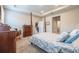 Bright main bedroom featuring a traditional wood four-poster bed and doorway to other rooms at 2898 Living Coral Dr, Odessa, FL 33556