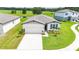 Picturesque aerial of a home with a manicured lawn, complemented by a tranquil pond and a spacious driveway at 3082 Forrest Plum Ct, Zephyrhills, FL 33540